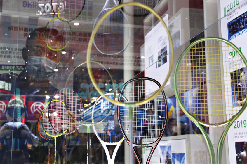 2020年11月6日，上海。观众在进博会参观日本羽毛球品牌展示的球拍。｜图源中新社张亨伟