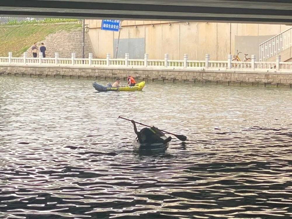 昆玉河里，一位桨板玩家正在躺划