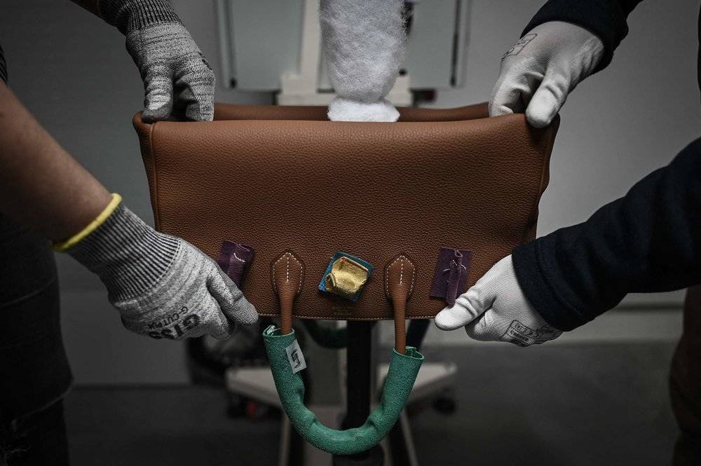 当地时间2022年1月6日，法国蒙布龙，法国高级时尚奢侈品制造商爱马仕皮具车间内，工人正在制作皮包。图片来源，视觉中国