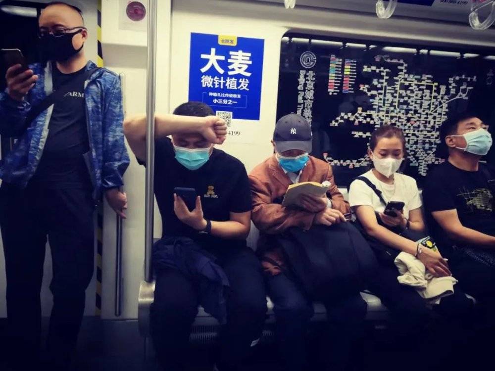 2021年9月27日北京地铁，年轻人在玩手机，长者在读罗素《权力论》 图片：王亚亚 周文远