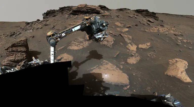 “毅力”号伸出机械臂，从叫做Skinner Ridge的露头收集岩芯，Skinner Ridge位于火星一个古老的河流三角洲。来源：NASA/JPL-Caltech/ASU/MSSS。<br label=图片备注 class=text-img-note>