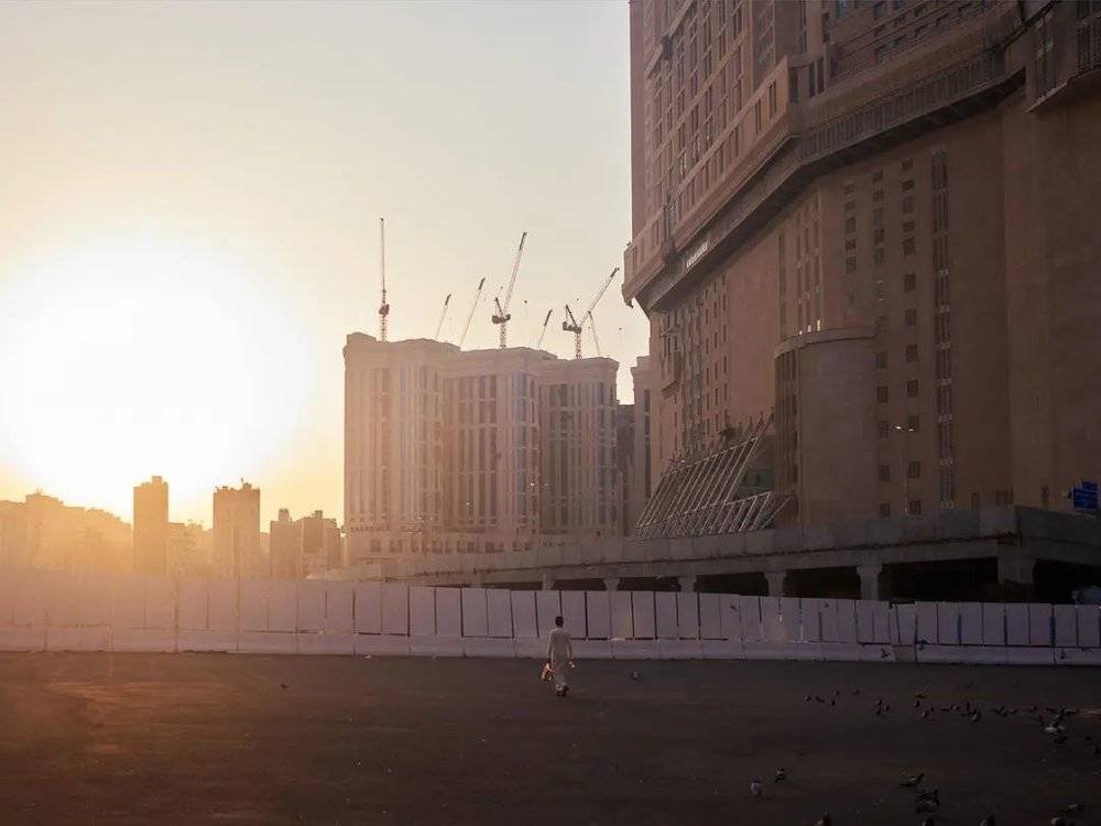 沙特麦加，钟楼饭店背后的巨大停车场，夕阳下的鸽子和一个孤独的哈吉。/李亚楠摄