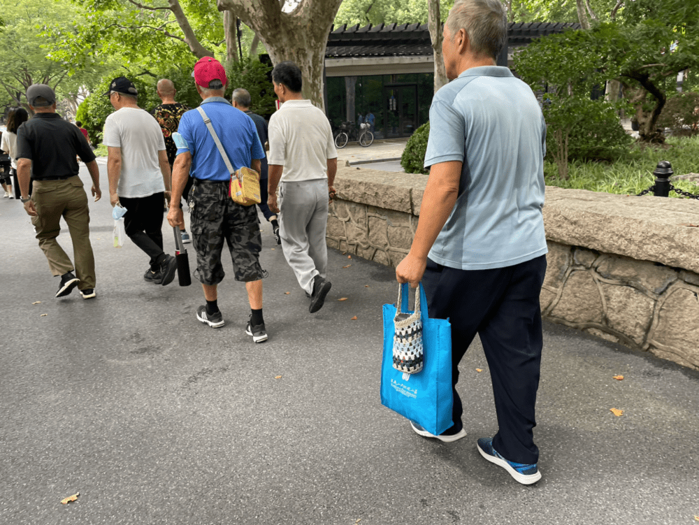 爷叔们拎着的钩针饮料袋，或许是太太的手作/图源：上海市民生活指南