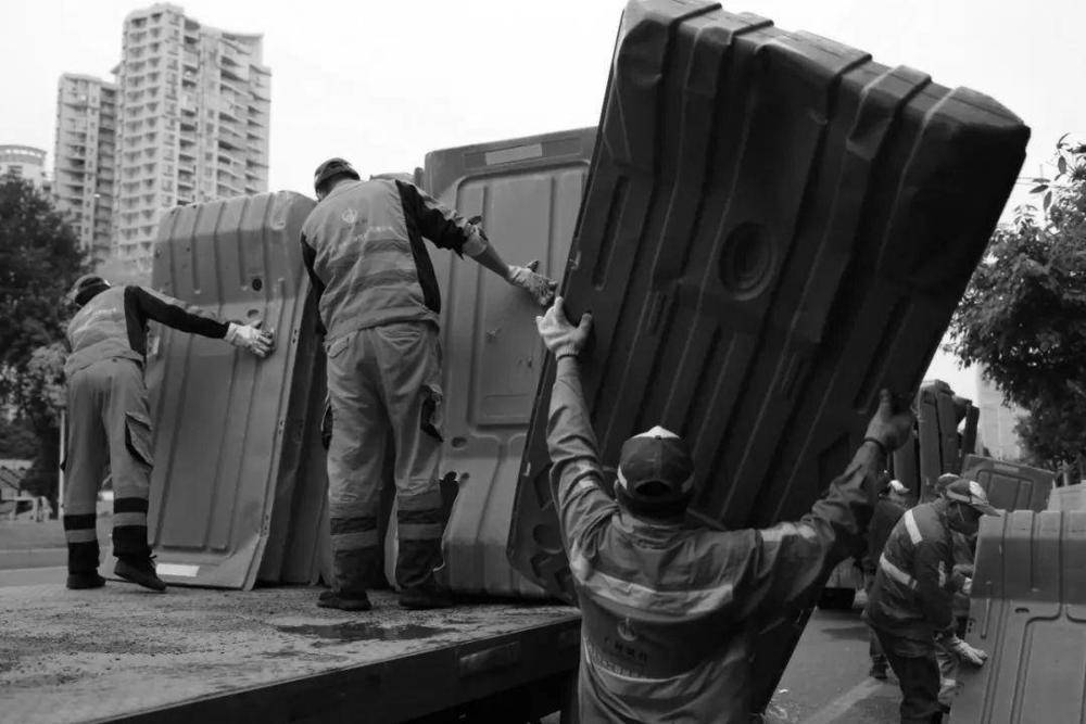 △广州大道，工作人员正在把围挡搬到运输车上。（摄影：禤灿雄）<br>