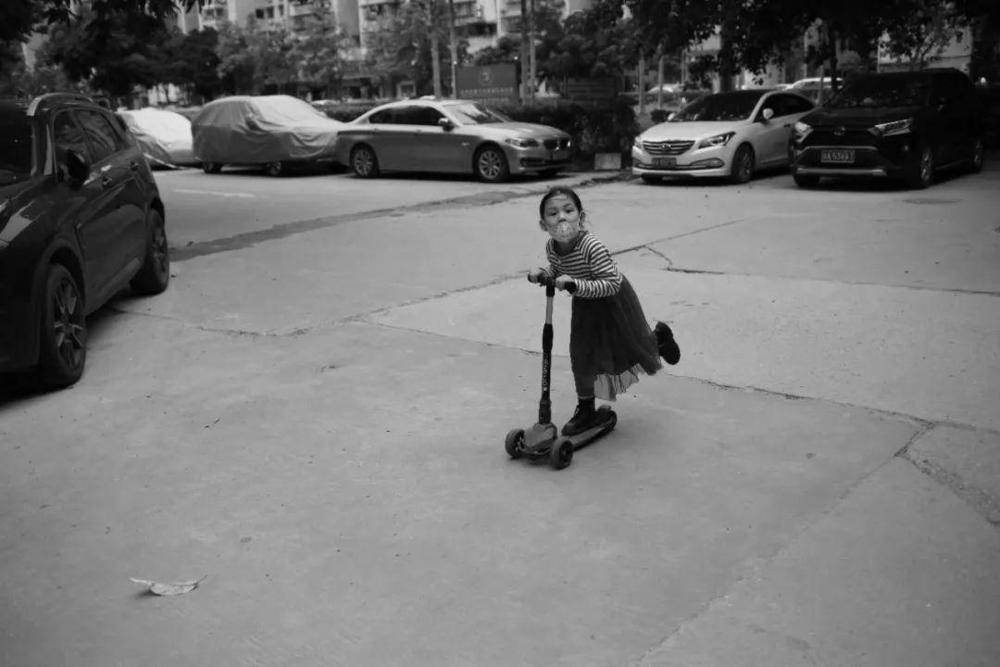 △天河棠下，蹬着滑板车路过的小女孩。（摄影：禤灿雄）<br>
