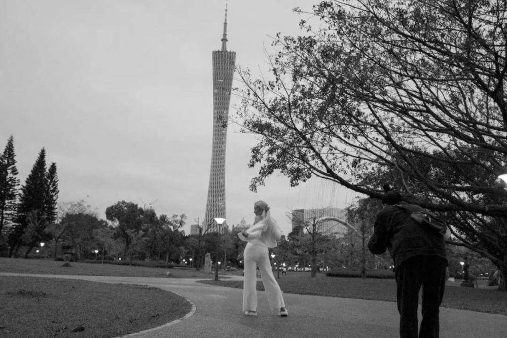 △二沙岛，一白衣女子正在与广州塔合影。（摄影：禤灿雄）<br>