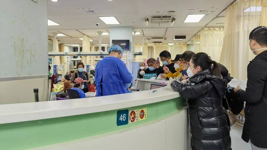 主治医师黄聪华在开医嘱，家属在护士站前排队等待着。林子璐 摄