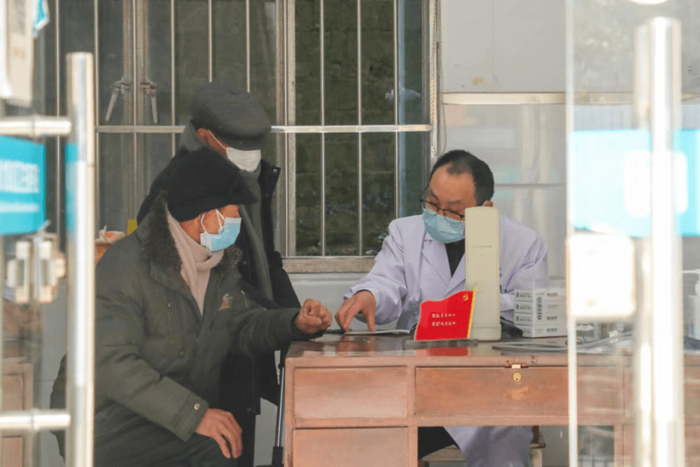 2022年12月28日，浙江宁波某村卫生室内，医生对两位老人进行问诊。照片由受访者供图