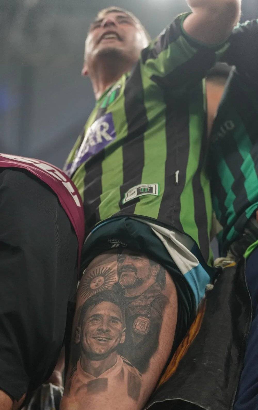 决赛，一名阿根廷球迷露出大腿上的马拉多纳与梅西纹身<br>