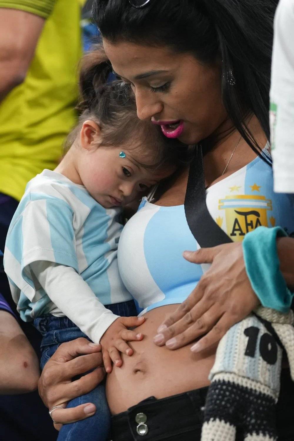 决赛，一名怀孕的阿根廷球迷抱着自己的女儿<br>