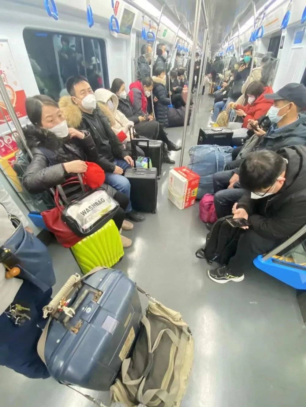  前往北京西站的地铁上，满是大包小包的旅客  摄影：王静仪