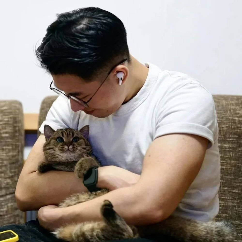 邓先生与他名叫“玲珑”的猫。/受访者供图<br>