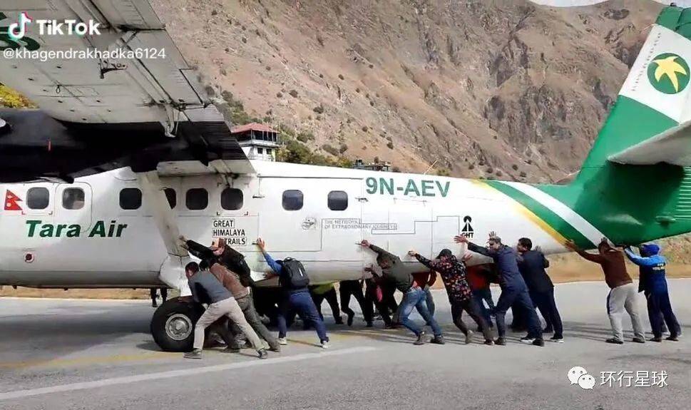 2021年12月1日，尼泊尔西部地区的巴朱拉机场（Bajura），乘客们帮忙将爆胎的飞机推开