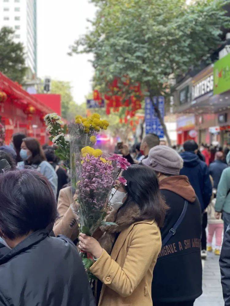 一位女士买完花后，兴奋地打电话给爸爸：“我买到花了，马上回家！”/牧羊 摄