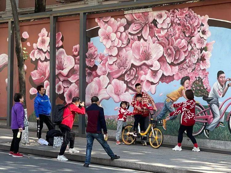 逛完花市，一大家人在府学西路的涂鸦边留影。/牧羊 摄