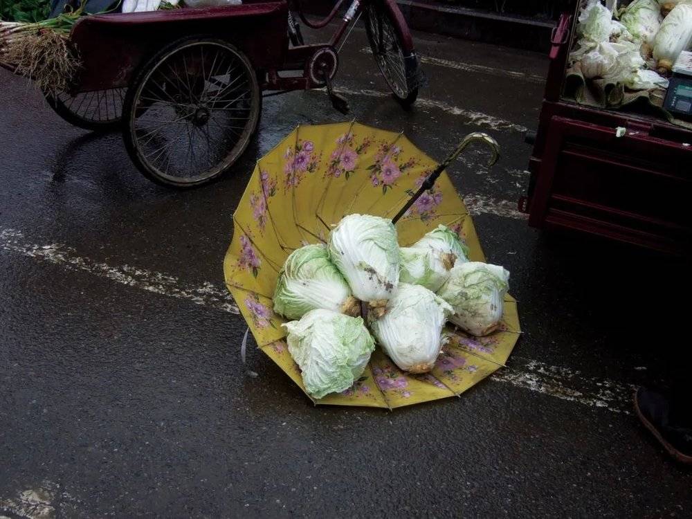 △菜市场里放大白菜的雨伞。<br>