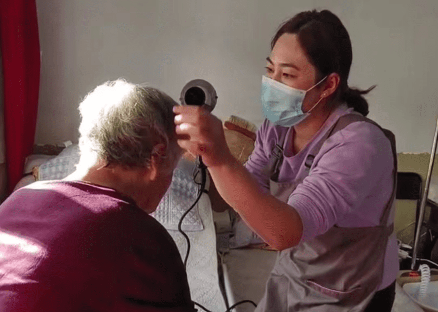 孔丹丹在帮奶奶吹头发，受访者供图