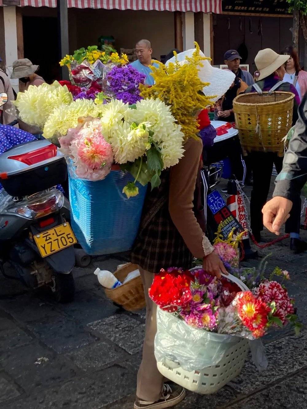 “大理古城的北门市场，在大理随处可见卖花的人，这些花很便宜，每个季节都有对应的花。家里的花从来不缺，也不用买，基本上都是从田野路边采回来的。”