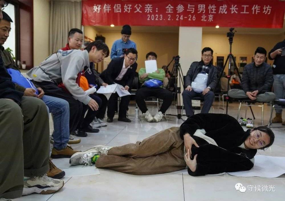 2月25日，北京一家宾馆会议室内，“男德班”课堂上，90后的小李挺着“孕肚”试图躺下，体验孕妇在日常生活中的种种不便。