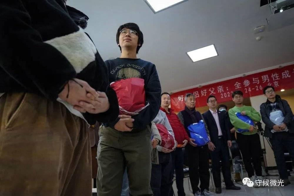 2月25日，北京一家宾馆会议室内，“男德班”课堂上，00后的北大物理学专业研究生小郭（左二）和学员们一起绑上几斤重的水袋，体验孕晚期孕妇的一天。