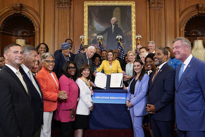 2022年8月12日，美国众议院议长南希·佩洛西在众议院民主党人的簇拥下，签署了《通胀削减法案》