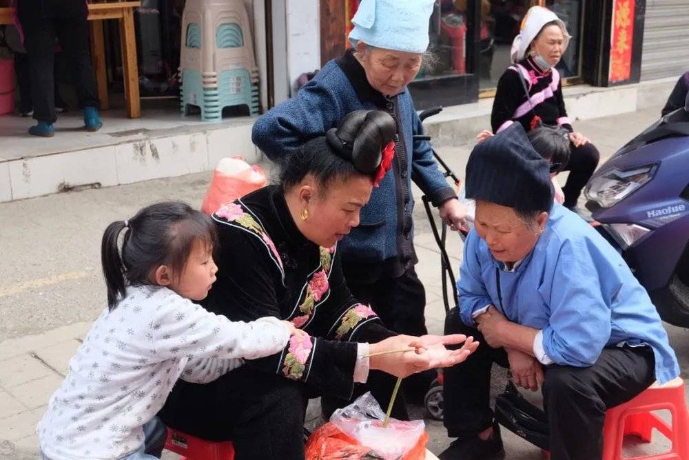 台江县的集市上，苗族人用大米进行占卜。图/新周刊记者摄<br>