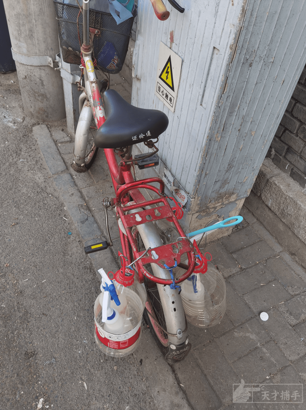 张元民的二手自行车后面挂着他的清扫工具。