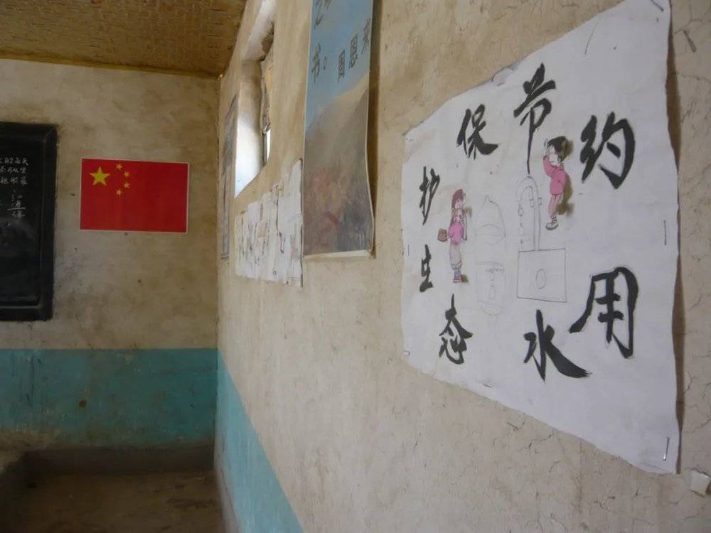 废弃了的乡村小学，孩子们期盼水的图画还贴在墙上。/王文明 摄<br>