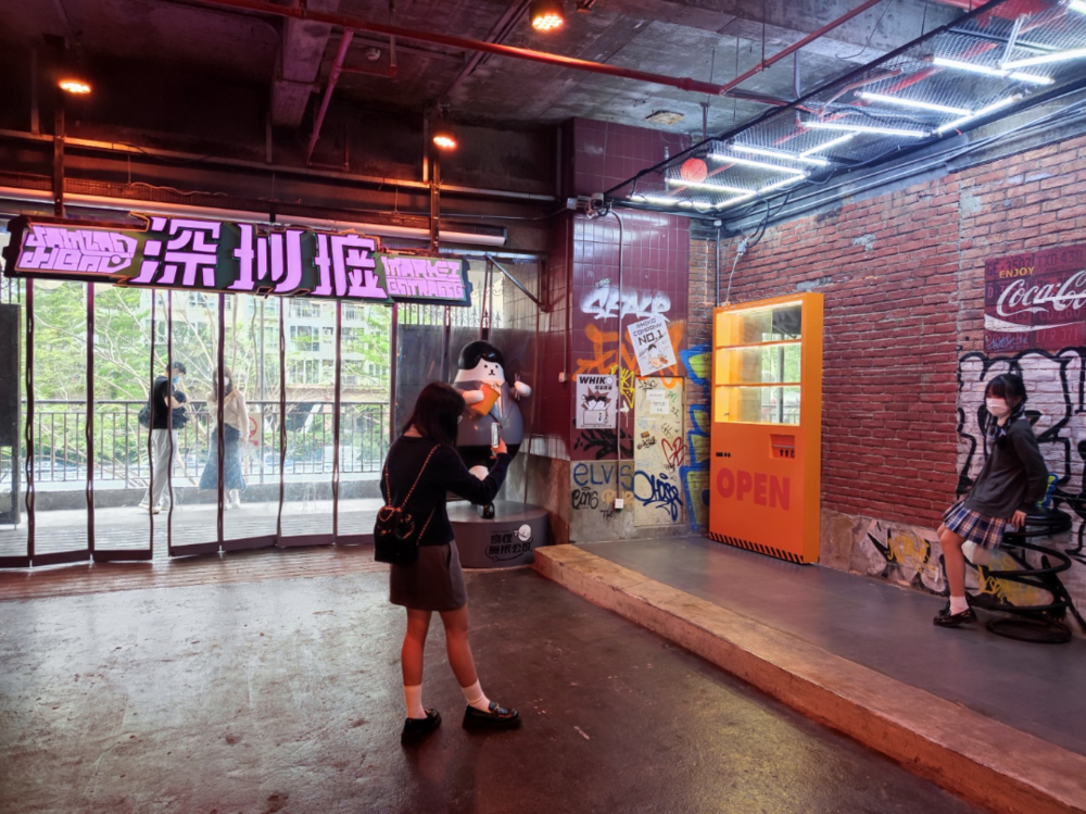 在“深圳墟”招牌下拍照打卡的女生<br>